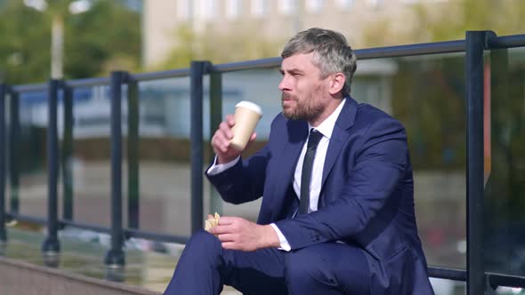 Businessman eating pizza outside