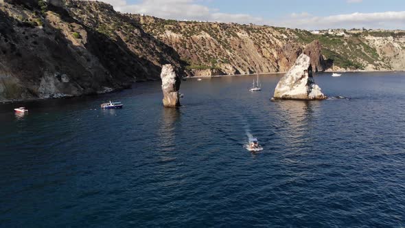 Aerial View of Tourist Boats in the Sea Bay Next To Individual Rocks and High Rocky Coast alt