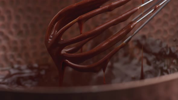 Melted chocolate dripping from whisk