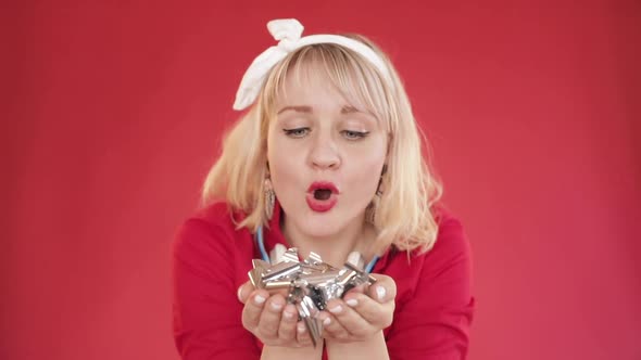 Pretty Girl with Headband Blowing Confetti at Camera alt