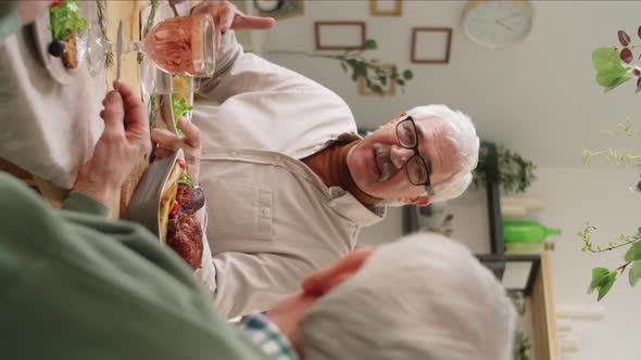 Cheerful Senior Man Chatting with Friend at Holiday Dinner alt