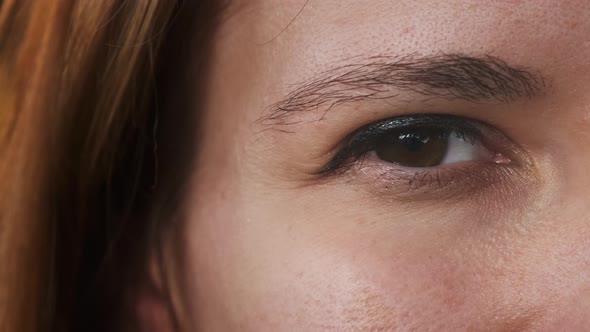 Brunette Woman Blinks with Eyemakeup and Long Lashes alt