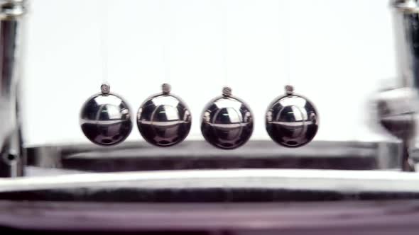 Slow motion shot of Newton's metal balls on white background. Close up
