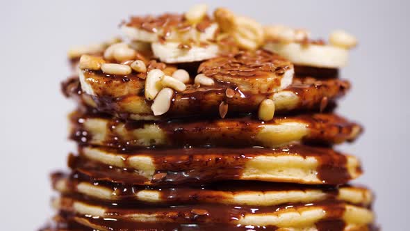 Pancakes with Chocolate Syrup, Nuts and Bananas. Stack of Whole Flapjack. Tasty Breakfast and alt