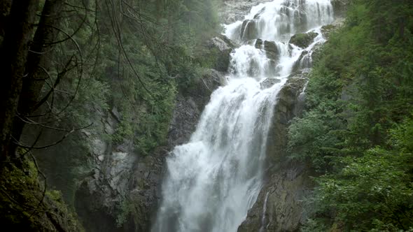 Tall Waterfall Flowing In Forest alt