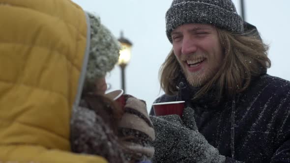 Portrait of Adorable Young People Man and Woman Drinking Tea or Coffee From Paper Cups at Seaside alt
