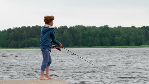 Red Haired Curly Boy With A Spinning Rod