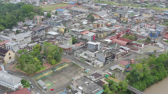 Aerial view of a large city in Ecuador, showing a worn down football field  alt