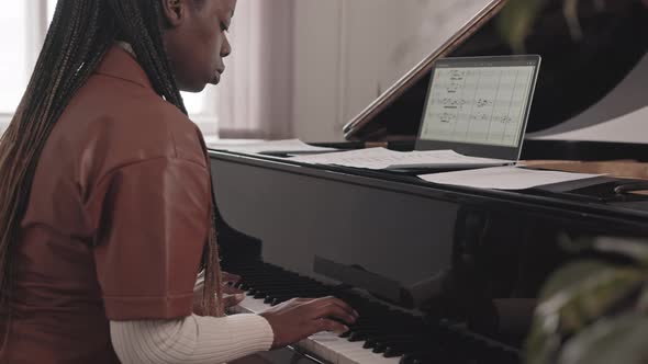 Young Black Woman Playing Grand Piano with Musical Notes alt