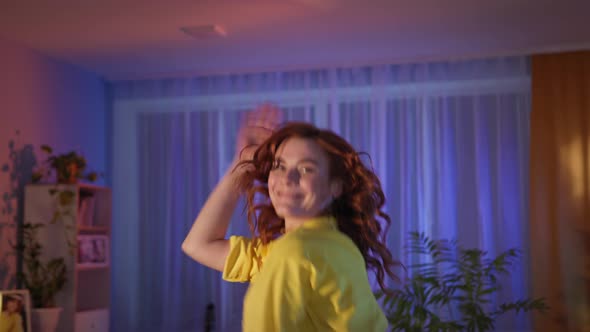 Woman Having Fun and Dancing in Room at Night Looking at Camera