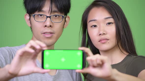 Young Asian Couple Showing Phone Together