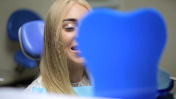 Girl in Dentist's Office Looking in the Mirror alt