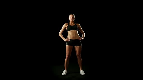 Young Athletic Woman Wearing Sporstwear is Warming Up Isolated on Black alt