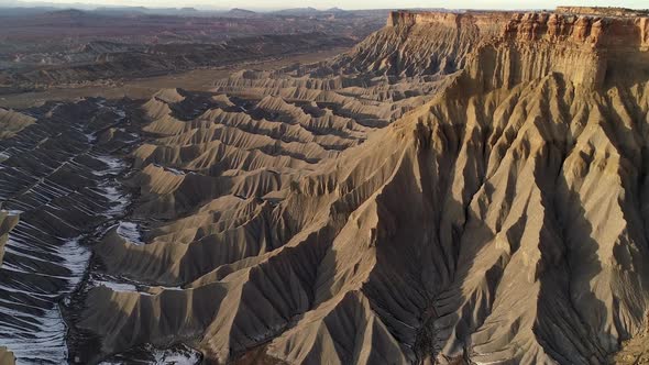 Flying along cliffs above the rugged terrain as the landscape glows alt