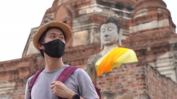Asian Man Smiling in Face Mask Traveling to Ayutthaya Thailand to Prevent From Coronavirus Covid19 alt