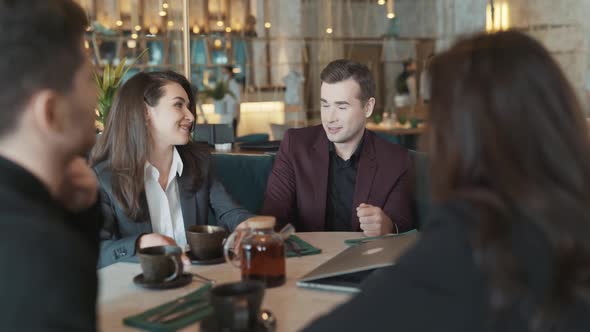 Diverse Group of Business Coworkers Sitting at a Table in Restaurant alt