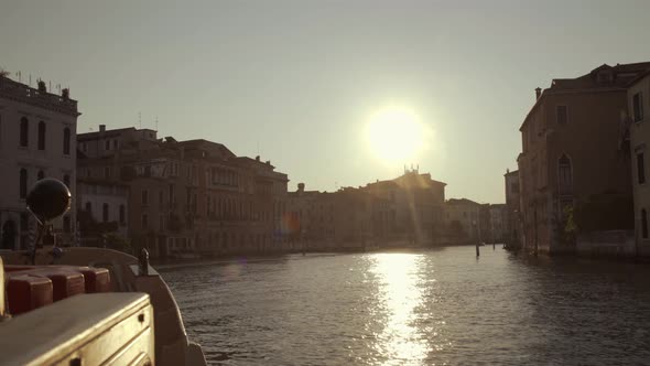 Front of a boat cruising towards morning sunrise in Canal Grande, Venice, Italy alt