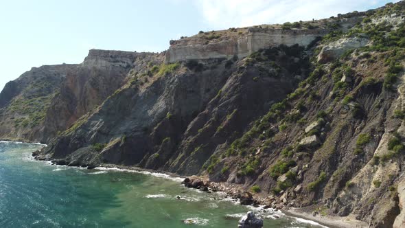 Aerial View From Above on Calm Azure Sea and Volcanic Rocky Shores alt