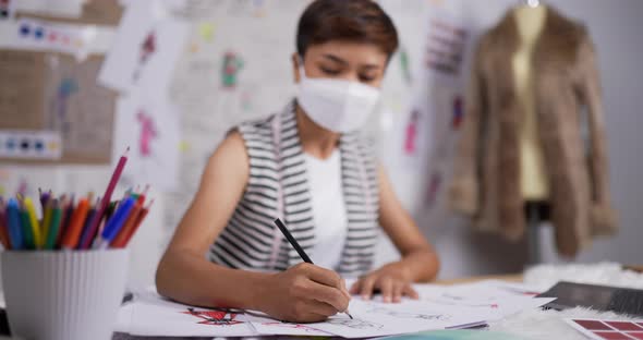 Fashion designer woman wear mask draws a sketch of women's clothing alt