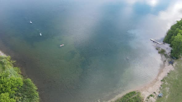 Birds eye view of lake on a bright autumn day. Paddle boards and kayaks in the water.