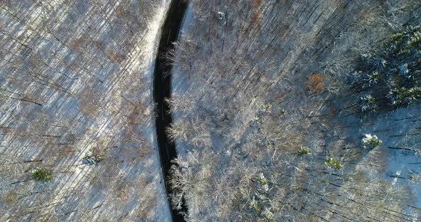 Aerial View Curvy Road Through Winter Forest