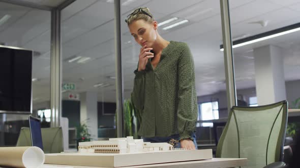 Video of focused caucasian female designer working on project alt