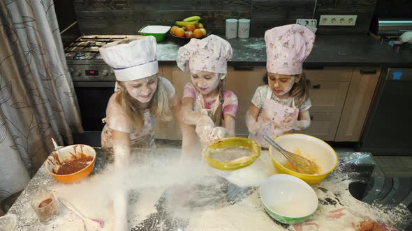 Three girls playing with flour alt