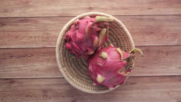 Hand Pick Dragon Fruit From a Bowl on Table alt