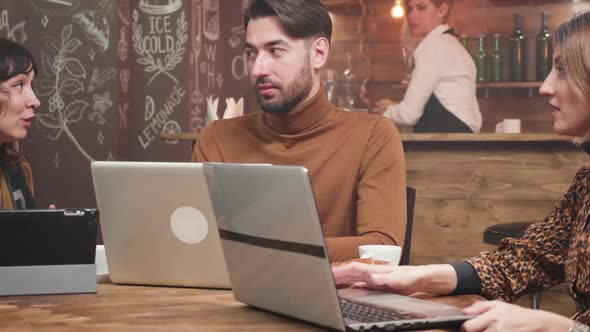 Young Freelance Entrepreneur Receiving Advice From His Female Colleagues alt