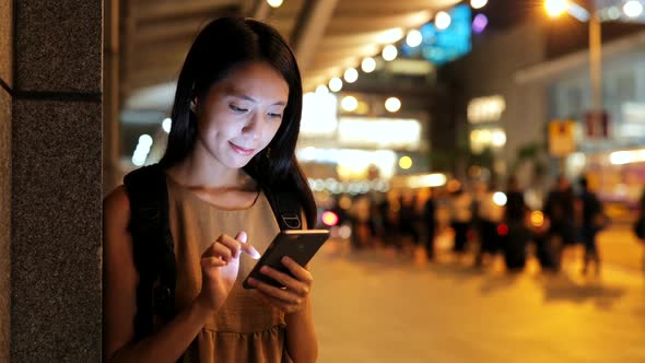 Woman using smart phone in Hong Kong at night  alt