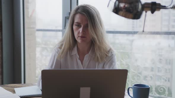 Young Woman Works for a Laptop in the Office Make the Business Correspondence alt