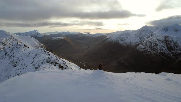 Mountaineer on the Summit of a Snowy Mountain alt