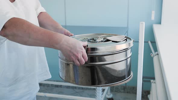 Female Surgical Nurse Worker Opens Steam Sterilizer Clean Drapes Inside alt