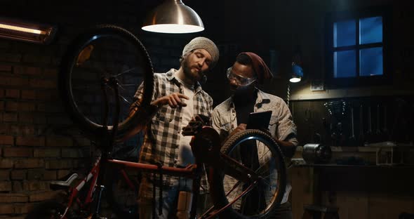 Two Mechanic Talking in a Workshop alt