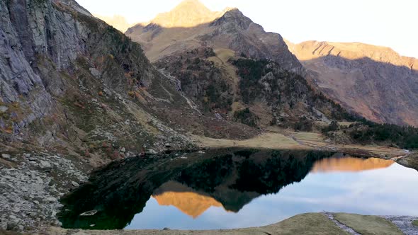 Lac d'Espingo lake  reflecting nearby peaks with calm water in Haute-Garonne, Pyrénées mountains, Fr alt