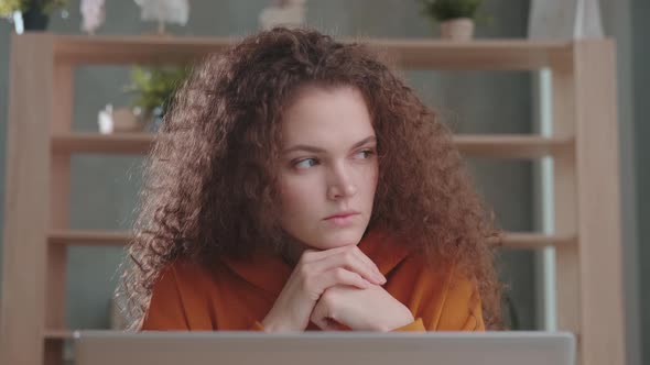 Focused Young Curly Woman Entrepreneur with Laptop Thinking About Work alt