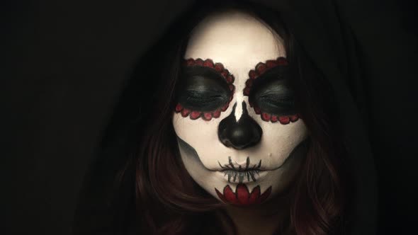 Lady with Santa Muerte Makeup Opens Eyes and Her Pupils Become Small alt