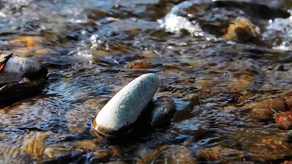 Dolly Slider Shot of the Splashing Water in a Mountain River Near Forest. Wet Rocks and Sun Rays alt