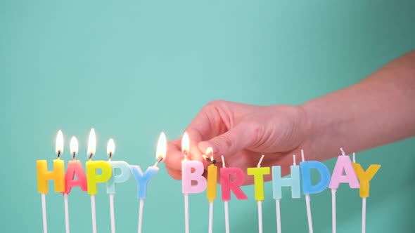 Happy Birthday Concept Made of Burning Colorful Candles on Blue or Turquoise Background