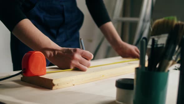 Woman Builder Using Roulette Wheel and Drawing Mark on Wooden Board Closeup alt