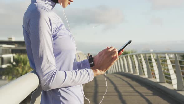 Woman wearing hijab listening music outside alt