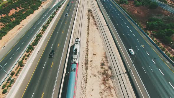A train travels near the highway. alt