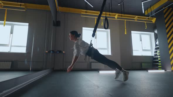 Indoor Workout with Strength Training Equipment Woman is Hanging and Doing Pushup Healthy Lifestyle alt