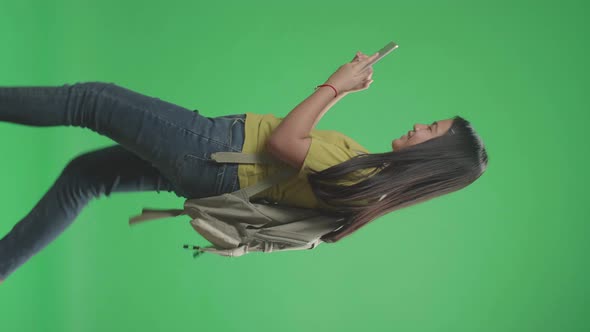 Side View Of Asian Girl Student Use Tablet And Walking To School On Green Screen Chroma Key alt