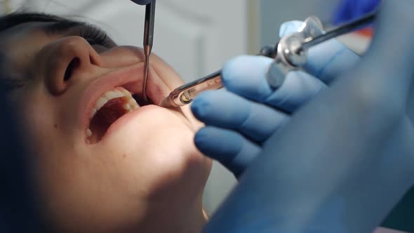 A Dentist Applies an Injection of Anesthetic Before Removing a Tooth to a Patient in a Dental Clinic