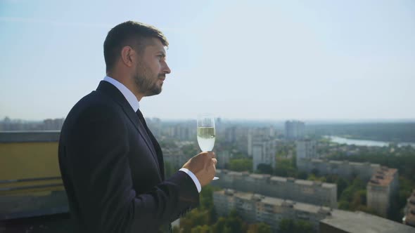 Thoughtful Male Worker Drinking Champagne From Glass, Office Outdoor Party