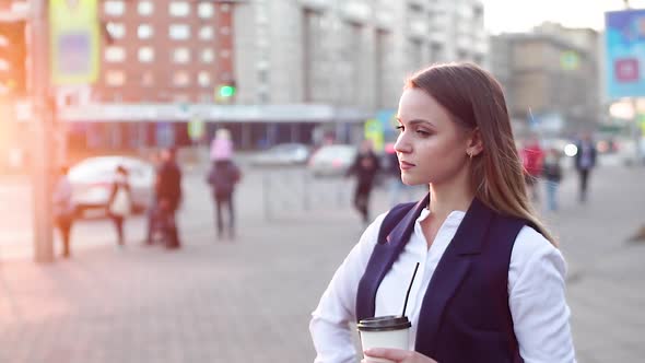 Attractive Girl with Coffee in The Evening, Standing in The City Center Near the Road.