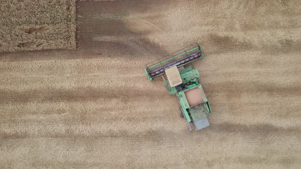 Aerial View of Harvester Machines Working in Wheat Field alt