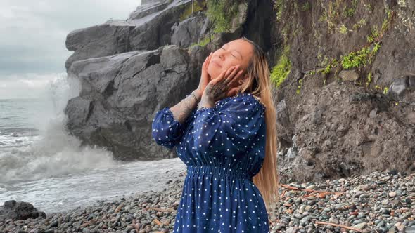 Happy Girl Enjoying the Rain at the Sea Coast