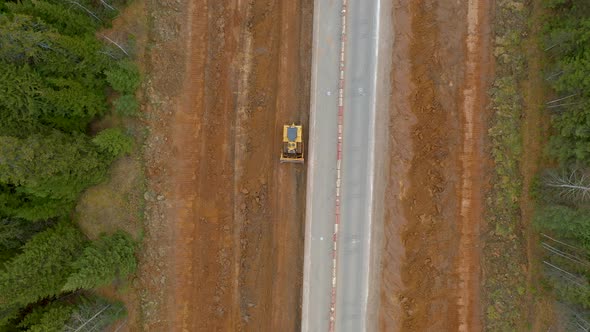 Crawler Bulldozer Levels Ground Widening and Repairing Road Aerial Top Down alt